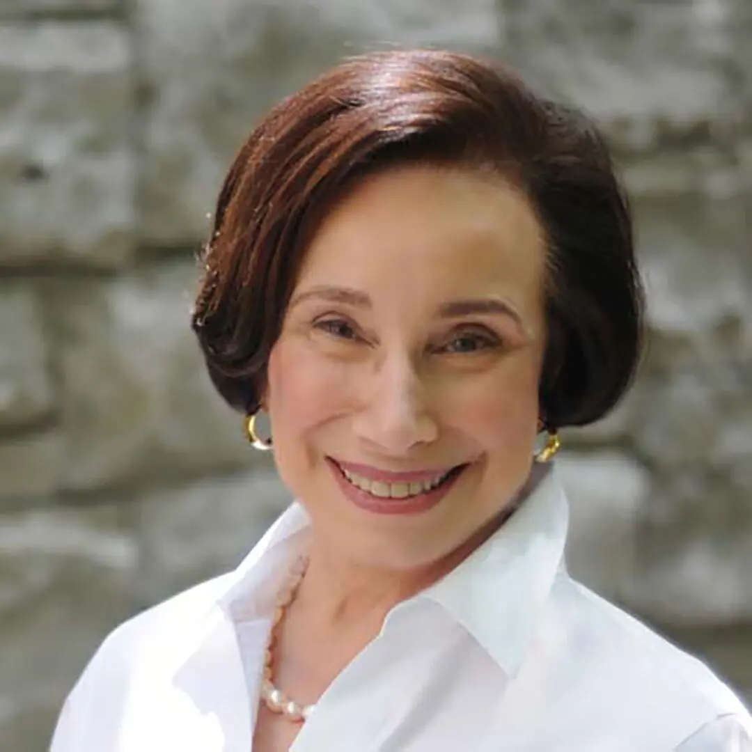 A woman with short hair wearing a white shirt.