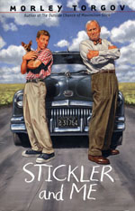 Two men standing in front of a car on the road.